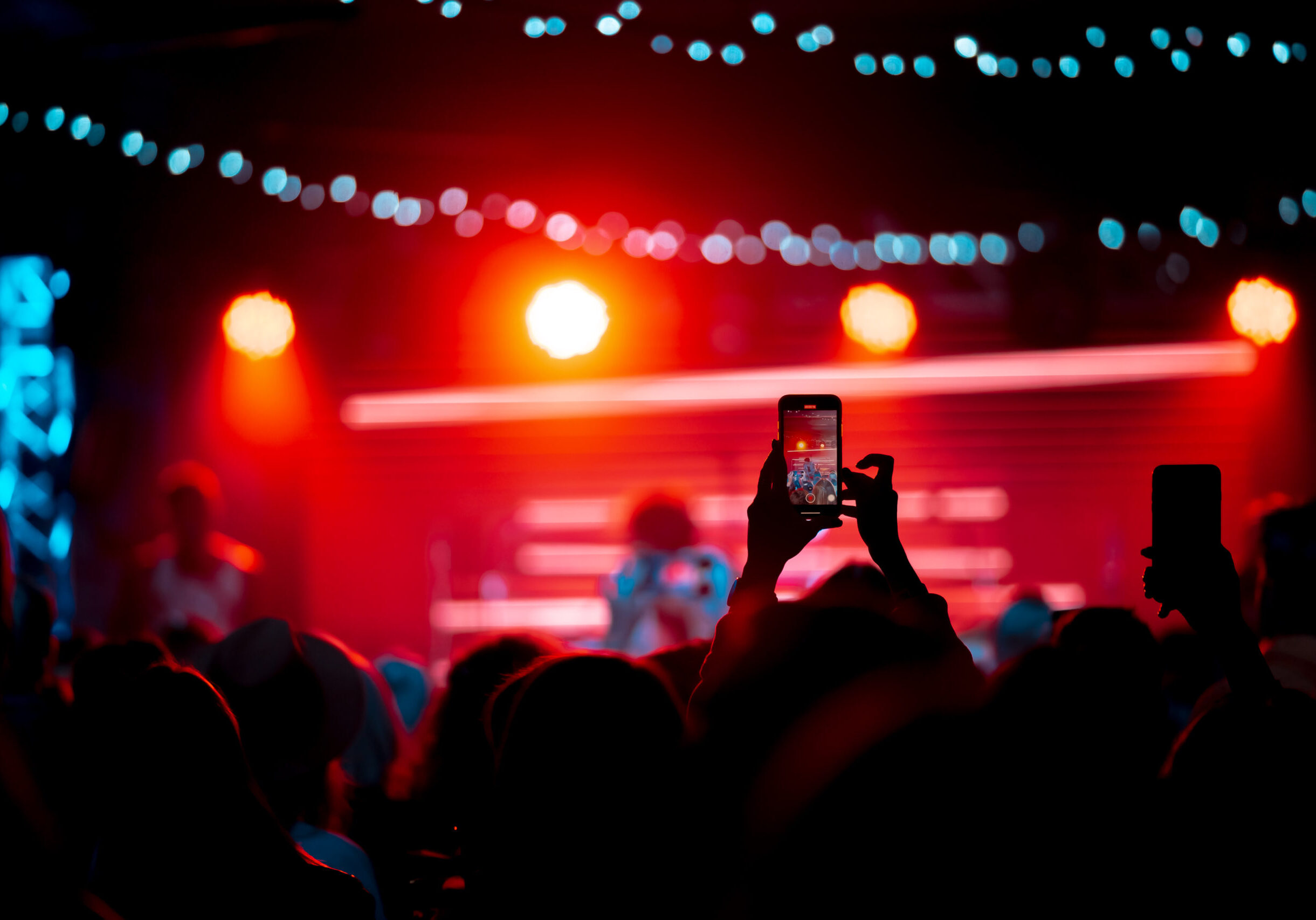 Close up of recording video with smartphone during a concert. Toned picture